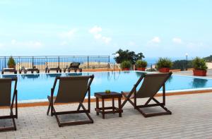 a group of chairs sitting next to a swimming pool at Berg Apartments in Bar