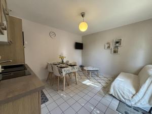 Una cocina y una sala de estar con una mesa. en Gîte à Contigny - Confort Tout Compris - FR-1-489-512, en Contigny 10 fotos más