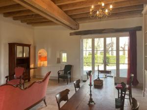 a living room with a large wooden table and chairs at Gîte lumineux avec piscine partagée et jardin privé - FR-1-489-557 in Meillard