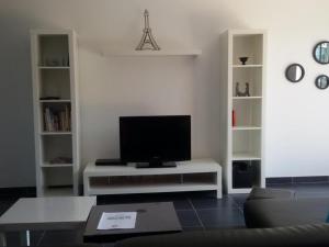 a living room with a flat screen tv on a table at Maison avec piscine chauffée, proche Châteaux de la Loire, confort et charme, animaux acceptés - FR-1-491-355 in Averdon