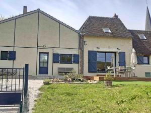 ein Haus mit einer Terrasse, einem Tisch und Stühlen in der Unterkunft Maison de campagne restaurée dans le Perche, animaux acceptés - FR-1-497-195 in La Roberie