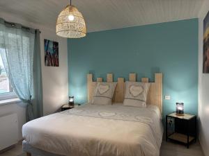 a bedroom with a white bed with a blue wall at Gîte paisible 6 pers proche Vichy et Clermont-Ferrand - FR-1-489-566 in Cognat-Lyonne