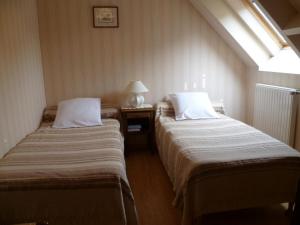 two beds in a room with a window at Maison charmante près des Châteaux de la Loire - Animaux admis - FR-1-491-407 in Cour-Cheverny