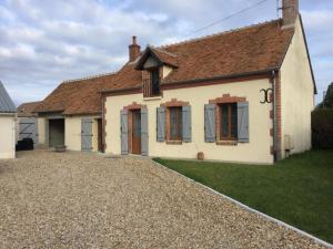 a house with a gravel driveway in front of it at Gîte familial en Sologne avec grand jardin, jeux pour enfants et proche des châteaux et commerces. - FR-1-491-373 in Mur-de-Sologne