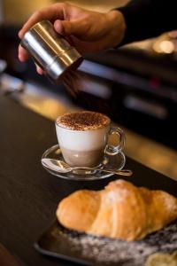 a person is pouring coffee into a cup on a table at La Smorfia in Naples