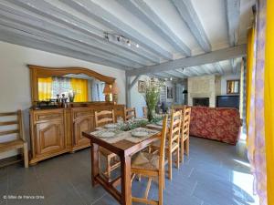 ein Esszimmer mit einem Holztisch und Stühlen in der Unterkunft Grande maison de campagne au calme avec jardin clos - FR-1-497-245 in Bocquencé