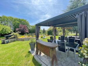 eine Holzbank in einem Garten mit einer Pergola in der Unterkunft Grande maison familiale, calme, nature, Wifi, animaux acceptés - FR-1-497-182 in La Gonfrière