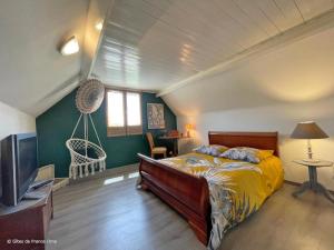 ein Schlafzimmer mit einem Bett und einem Flachbildfernseher in der Unterkunft Grande maison familiale, calme, nature, Wifi, animaux acceptés - FR-1-497-182 in La Gonfrière