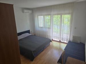 a bedroom with a bed and a window at Rajčić Apartmani in Omiš
