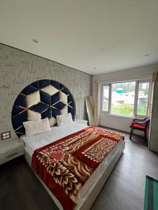 a bedroom with a large bed with a large headboard at Pearl Residency in Pahalgām