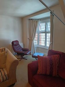 a living room with two couches and a chair and a window at Chandeliers 6 in Shrewsbury