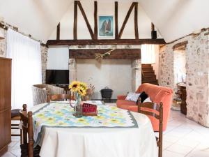 a living room with a table with a vase of flowers on it at Maison spacieuse 3 ch, Wifi, animaux admis, terrasse, garage - Le Lardin-Saint-Lazare - FR-1-616-220 in Le Lardin-Saint-Lazare