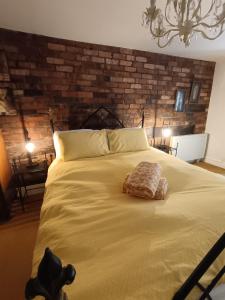a bedroom with a large bed with a brick wall at Chandeliers 6 in Shrewsbury