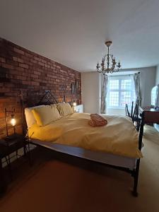 a bedroom with a large bed with a brick wall at Chandeliers 6 in Shrewsbury