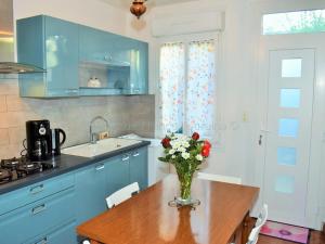 eine Küche mit einer Vase aus Blumen auf einem Holztisch in der Unterkunft Gîte de charme en Touraine avec jardin privatif - FR-1-381-436 in Montlouis-sur-Loire + 13 Fotos