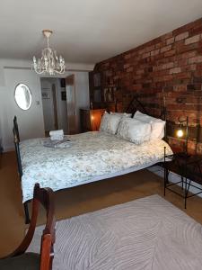 a bedroom with a bed and a brick wall at Chandeliers 6 in Shrewsbury +32 photos