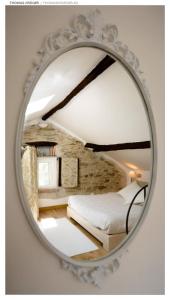 einem Spiegel, der ein Schlafzimmer mit einem Bett reflektiert in der Unterkunft Pin de stèlle in San Martino