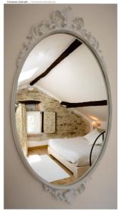 a mirror reflecting a bedroom with a bed in it at Pin de stèlle in San Martino