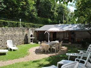 a patio with a table and chairs and a building at Gîte rural rénové 3 niveaux, jardin privatif, équipements loisirs, draps inclus, cheminée, WiFi - FR-1-381-475 in Bléré