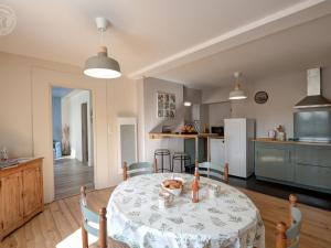 a kitchen and a dining room with a table at Chazelles-sur-Lyon : Appartement cosy avec Wi-Fi, terrasse et salon agréable - FR-1-496-298 in Chazelles-sur-Lyon +2 photos