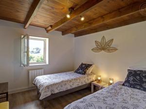 a bedroom with two beds and a window at Gîtes Champêtres Rénovés avec Terrasse, Jardin, et Activités pour Familles et Amis - FR-1-496-304 in Belmont-de-la-Loire
