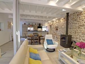a living room with a white couch and a stone wall at Gîte de charme avec SPA, terrasse, cheminée et cour, idéal pour un séjour zen à Notre-Dame-de-Boisset - FR-1-496-320 in Notre-Dame-de-Boisset