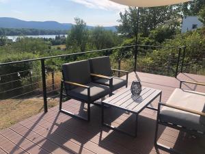 a patio with two chairs and a table on a balcony at Házikó a Domboldalon in Verőce