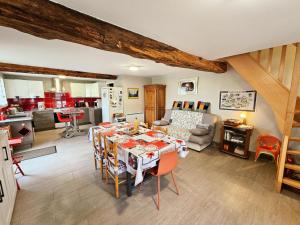 Una cocina y una sala de estar con mesa y sillas. en Charmant gîte en pierre près de Chinon, jardin privatif - FR-1-381-608, en Sazilly
