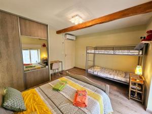 Un dormitorio con dos literas y un espejo. en Charmant gîte en pierre près de Chinon, jardin privatif - FR-1-381-608, en Sazilly