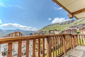 a balcony with a view of a city at Stylish 2BR Ski-In Apartment - Heart of Val Thorens, Amazing Views & Parking in Val Thorens +7 photos