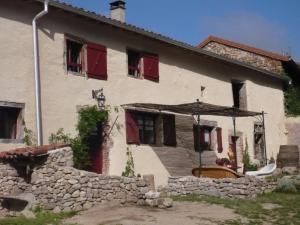 ein altes Haus mit roten Fensterläden und einem Regenschirm in der Unterkunft Charmant Gîte pour 4 avec Jardin, Animaux Bienvenus - FR-1-496-191 in Saint-Georges-Haute-Ville