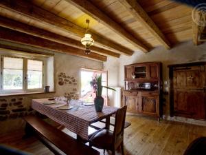 ein Esszimmer mit Tisch und eine Küche in der Unterkunft Charmant Gîte pour 4 avec Jardin, Animaux Bienvenus - FR-1-496-191 in Saint-Georges-Haute-Ville + 9 Fotos