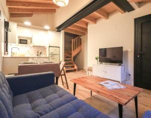 a living room with a couch and a table and a kitchen at MC Vega- Mi Casina con vistas al mar in Ribadesella