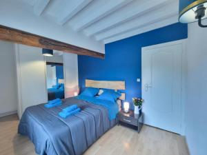 a blue bedroom with two beds with blue sheets at Gîte de charme avec terrasse, jardin et jeux - tout inclus, lits faits, linge fourni à Saint-Galmier - FR-1-496-300 in Saint-Galmier