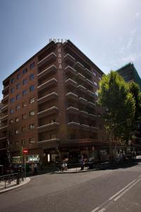 um grande edifício de tijolos ao lado de uma rua em Hotel Praga em Madrid