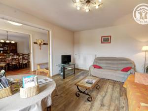 una sala de estar con un sofá y una mesa en Gîte rural familial avec jardin, terrasse et équipements modernes près du Parc Livradois Forez - FR-1-496-22, en Chérier