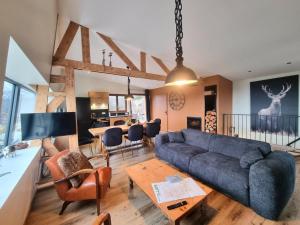 a living room with a couch and a table at Gîte chaleureux au Bessat pour 6 à 8 pers., animaux admis, grand jardin - FR-1-496-350 in Le Bessat