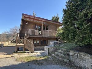 a log house with a large deck and a porch at Gîte chaleureux au Bessat pour 6 à 8 pers., animaux admis, grand jardin - FR-1-496-350 in Le Bessat