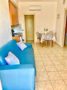 a living room with a blue couch and a table at ONDA BLU in Diano Marina +3 photos