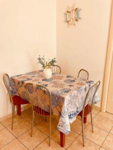 a dining room table with chairs and a plant on it at ONDA BLU in Diano Marina