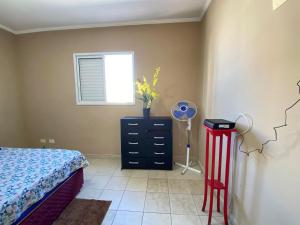 ein Schlafzimmer mit einem Bett, einer Kommode und einem Fenster in der Unterkunft Apto c/ vista mar e piscina no prédio perto do mar in Samaritá + 15 Fotos
