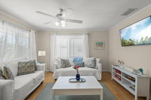Una sala de estar con un sofá y un televisor en Coastal Breeze Siesta Turtle "B", en Sarasota