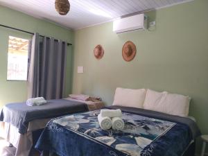 a bedroom with two twin beds with towels at pousada da Serra PETAR in Iporanga