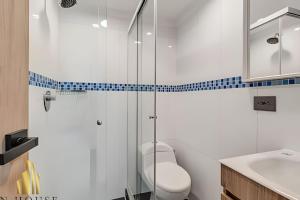 a bathroom with a toilet and a glass shower at Paola 201 - Charm and perfect location in Laureles in Guayaquil