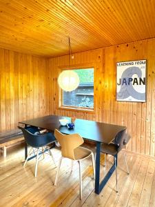 a dining room with a black table and chairs at Architectural Cottage On 7000 Sqm Nature Plot in Hadsund +31 photos