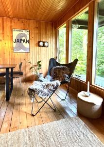 a living room with a chair and a table at Architectural Cottage On 7000 Sqm Nature Plot in Hadsund