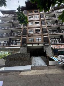 a large building with a sign on the front of it at Cozy Brenthill Condo in Baguio City - Entire House Rental in Baguio