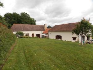 a couple of buildings with a grass yard at Gîte de charme rural avec terrasse, jardin privé, chevaux à proximité et équipements modernes - FR-1-489-213 in Neuvy