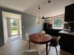 eine Küche mit Tisch und Stühlen in einem Zimmer in der Unterkunft Gîte contemporain avec climatisation et parking dans un village historique - FR-1-489-551 in Ébreuil + 16 Fotos