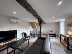 a living room with a couch and a table at Gîte historique rénové avec jardin et WiFi - FR-1-489-571 in Theneuille